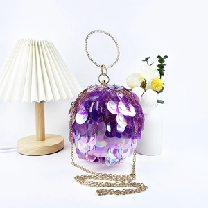 Detail of purple iridescent sequins on spherical evening bag with golden chain strap