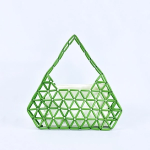 Detail of green handmade beaded handbag featuring geometric pattern and white inner pouch