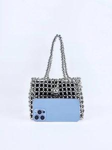 Detailed silver beaded handbag with fabric lining next to a phone for size reference