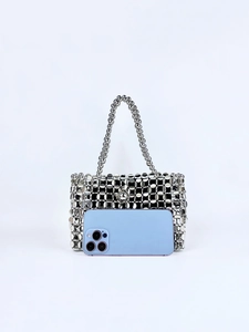 Macro view of silver beaded pearl bag with hollow geometric metal ring weave and handle