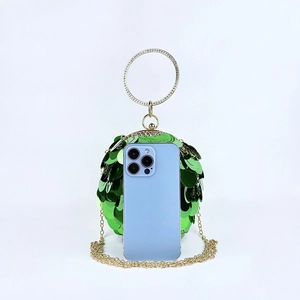 Detail of green sequin spherical clutch bag with diamond-studded gold ring and metal chain