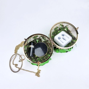 Macro view of green sequin sphere evening bag showing capacity with cosmetics inside