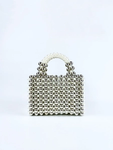 Detail of handcrafted beaded handbag with silver metal beads and white faux pearls