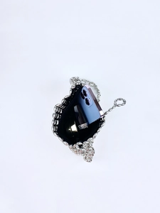Detail of silver metallic beaded bag showing interior capacity with phone and cosmetics