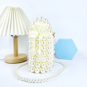 Detailed macro view of handmade white pearl bucket bag with satin drawstring liner