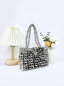 Silver sequin woven handbag with beaded straps shown in elegant home decor setting