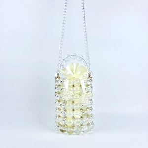 Macro detail of handmade clear beaded bag with gold accents and silk drawstring liner