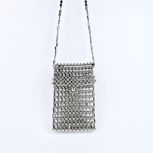 Detail of silver beaded mini crossbody bag featuring metallic weave and spherical buckle