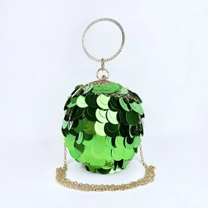 Macro view of green sequin evening clutch featuring gold rhinestone ring handle