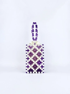 Detail of beaded handbag showing white pearls and purple beads with satin lining texture