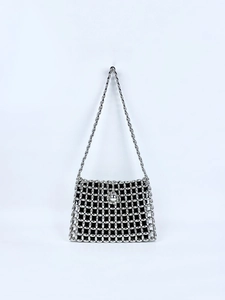 Close-up of silver metal beads weaving structure and circular lock on the handbag