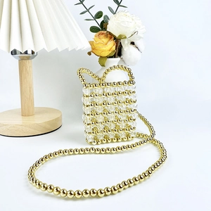 Detail of handmade mini beaded crossbody bag with gold metal beads and clear crystals