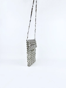 Detail of silver metallic disc woven crossbody phone bag with chain strap and industrial texture