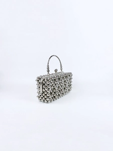 Detail of silver beaded evening clutch bag with metallic top handle and sphere clasp