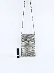 Detail of silver beaded handmade phone bag with metallic strap and lipstick for scale