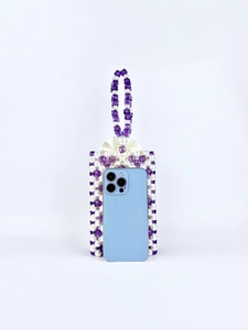 Macro view of handcrafted purple and white beaded phone bag with pearl-like texture
