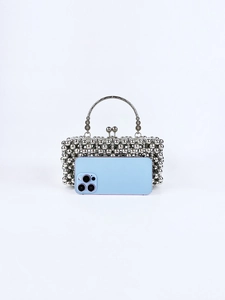 Silver beaded evening bag with floral metal handle shown next to a smartphone for size reference