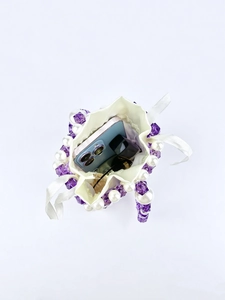 Top view of a purple beaded mini bag showing interior storage with a smartphone
