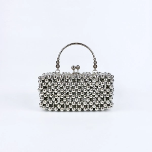 Detailed view of silver metal beaded evening bag with a semi-circular metal handle