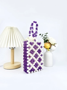 Elegant beaded handbag featuring purple square beads and white pearls in a diamond pattern