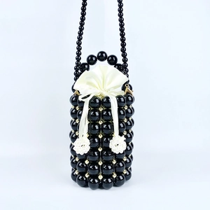 Macro view of handmade black beaded bucket bag with cream satin drawstring lining