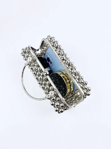Detail showing internal space of silver beaded evening bag with metal floral handle