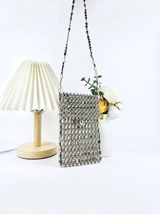 Handmade silver beaded crossbody bag with metallic beads and slim chain on white background