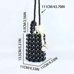 Detail view of black beaded bucket bag with dimensions showing size and strap length