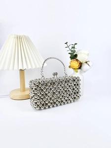 Elegant silver beaded handbag with metal top handle and floral relief accents
