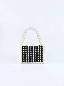 Détail d'un sac à main artisanal en perles avec motif à rayures verticales noir et blanc