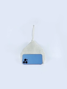 Detail view of pearl beaded handbag with smartphone inside showing storage capacity