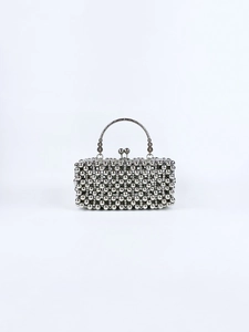 Detail of silver beaded clutch bag featuring elegant metal handle and dual bead clasp closure