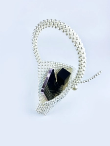 Detail view of triangular pearl beaded bag showing phone and lipstick storage capacity