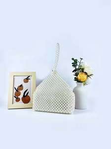 Elegant white pearl woven handbag with a unique triangular shape and large bead closure