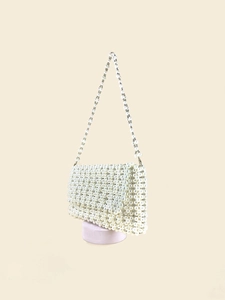 Detail of handcrafted white pearl woven shoulder bag with rectangular flap and beaded strap