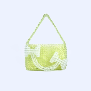 Detail of neon green acrylic beaded handbag featuring white smiling face motif