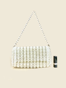 Detailed view of handmade pearl woven handbag with lipstick for size scale reference