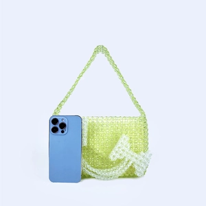 Detail of green handmade beaded mini bag with white sickle and hammer pattern