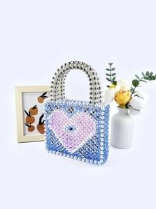 Blue beaded heart handbag with Evil Eye motif and pearl handle on white background