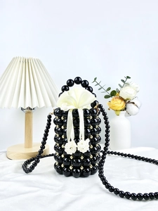 Handmade beaded bucket bag in black and gold with white satin drawstring liner