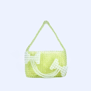 Detail of handmade light green acrylic beaded shoulder bag with white bow pattern