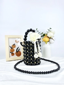 Handmade beaded bucket bag in glossy black with gold accents and drawstring satin liner