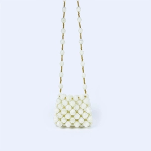 Detail van een handgemaakte ivoren parel crossbody tas met een unieke kralentextuur