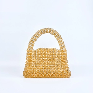 Gros plan du sac à main perlé fait main avec perles acryliques champagne et texture