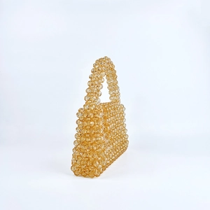Vue détaillée du sac à main artisanal en perles ambrées avec une texture géométrique tissée