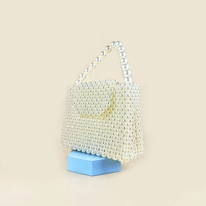 Macro shot of handcrafted white pearl beaded handbag with elegant box-shaped flip cover