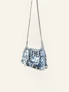 Detail view of shimmering silver metal sequins and chain strap on evening bag