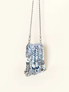 Detail of silver sequin texture on evening bag with delicate metallic chain strap