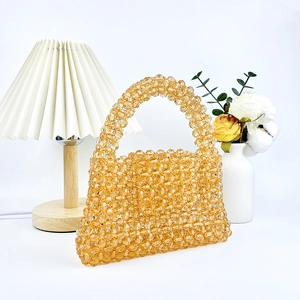 Gros plan détaillé d'un sac à main artisanal en perles acryliques ambrées à facettes