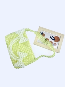 Handmade lime green beaded shoulder bag featuring a white HE letter pattern design